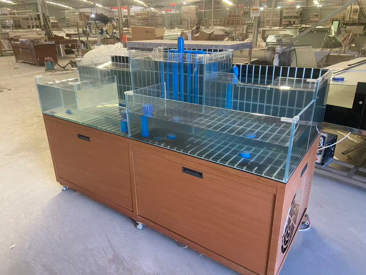 Owner-supplied custom live seafood island tank with compartmented glass tanks and wood-tone cabinet; configuration reference